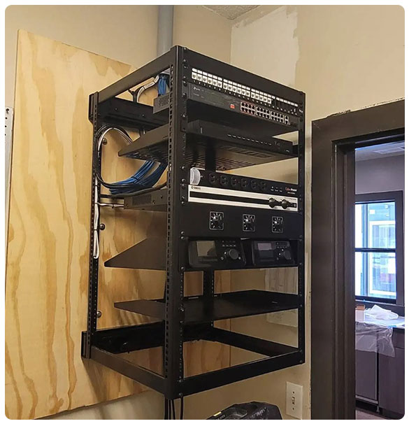 Structured cabling rack with various audio-video equipment and network components, showcasing installation for commercial AV and low-voltage solutions in Atlanta businesses.