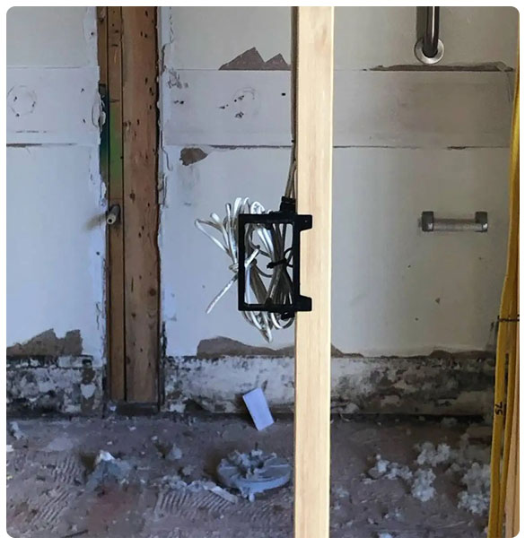 Low-voltage wiring installation in a commercial space, showcasing structured cabling for security and AV systems, with exposed walls and construction materials.