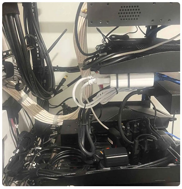 Centralized data rack with organized networking equipment and cables, supporting audio-visual system and internet connectivity for residential barndominium project in Social Circle, GA.