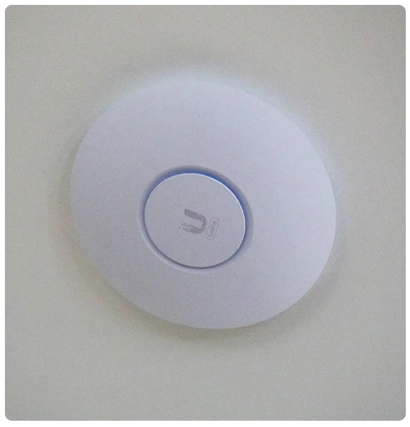 Ceiling-mounted wireless access point for enhanced Wi-Fi connectivity in church fellowship hall, part of comprehensive networking infrastructure installation by SAV Systems.