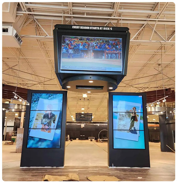 Digital signage installation at Dick's Sporting Goods showcasing promotional content and sports events in a modern retail environment.