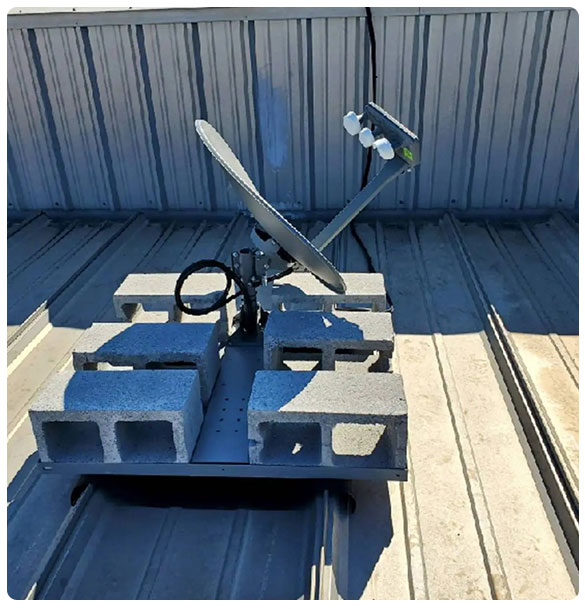 Starlink satellite dish installation on a rooftop, secured with concrete blocks for stable high-speed internet connectivity at McDonough Dental Studio.