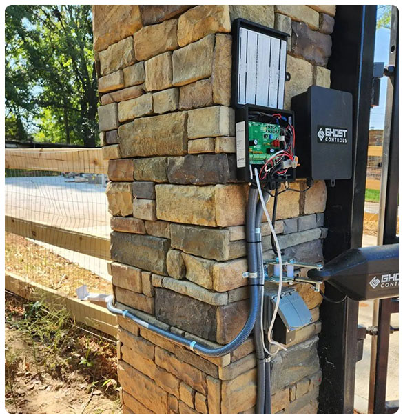Automatic gate operator installation on stone pillar, featuring control panel and wiring, enhancing security and access for residential new construction in Auburn, GA.