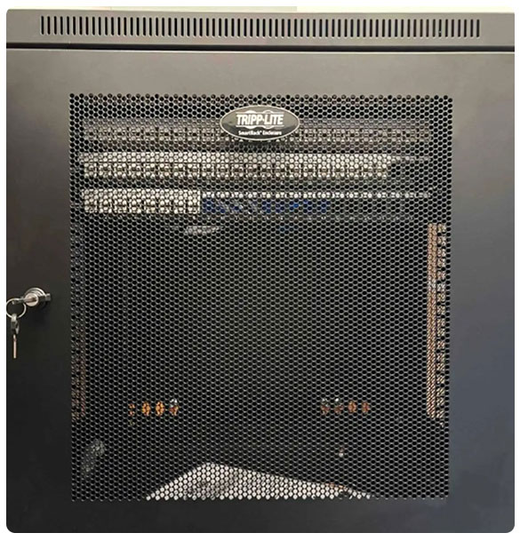 Network rack enclosure from Tripp Lite, showcasing organized audio-visual and networking equipment for dental clinic technology integration.
