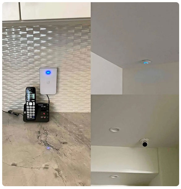 Residential basement technology installation featuring a VoIP phone, network access point, and ceiling-mounted security camera, illustrating advanced networking and security enhancements.
