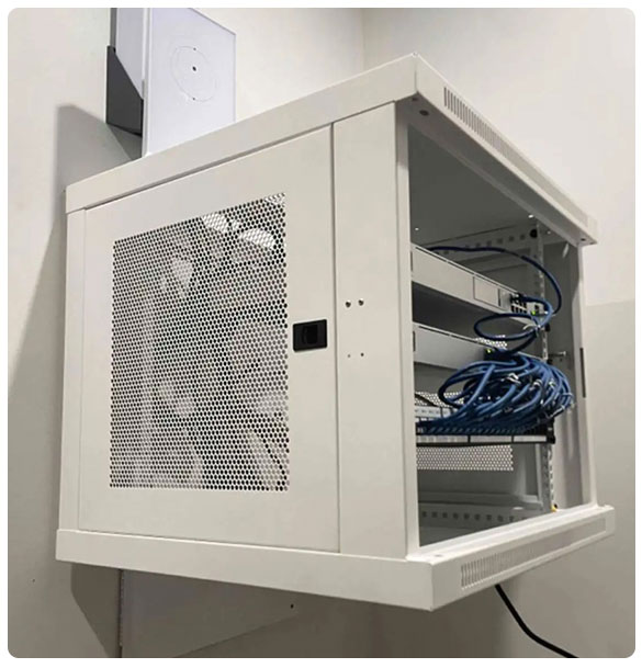 Networking equipment rack with multiple cables and devices, part of SAV Systems' comprehensive networking suite for Standridge Color Corp, ensuring reliable internet access and supporting advanced audio-visual solutions.