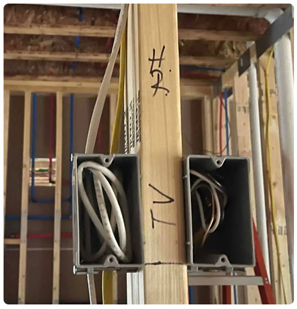 TV wiring boxes mounted on a wooden beam in a construction setting, showcasing electrical setup for multiple TVs as part of a comprehensive audio and video installation project by SAV Systems.